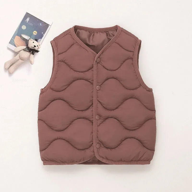 A solid mauve quilted vest for a child, displayed next to a small stuffed animal.
