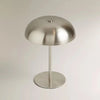A modern, silver-toned portable touch table lamp with a dome shade and a cylindrical stand.
