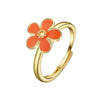 En guldtonad ring med skuren blomdesign i orange och gula accenter.