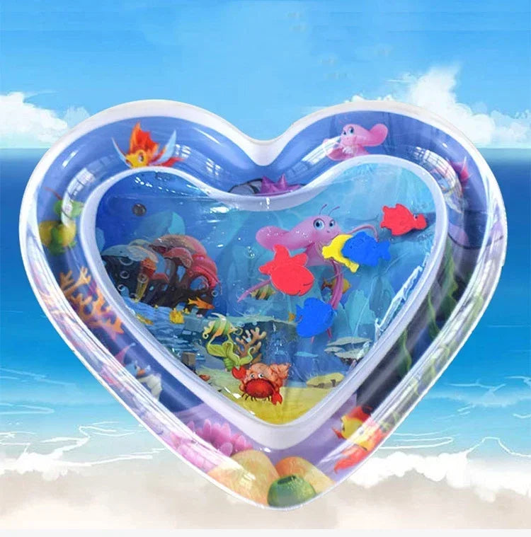 A heart-shaped inflatable baby water play mat featuring colorful sea creatures and a blue ocean background.