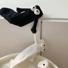 A pair of black and white cartoon couple socks with fun hand designs displayed on a shelf.