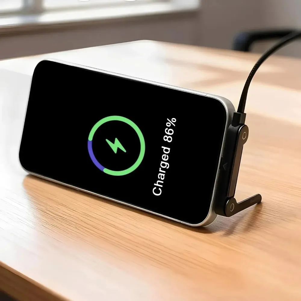 هاتف ذكي أسود يشحن عبر كابل USB-C مع حامل قابل للطي، ويظهر الشحن بنسبة 86%.
