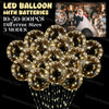 A bundle of gold LED light-up balloons with pre-strung lights shown against a dark background.