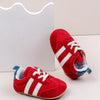 A pair of red and white Adidas style baby first walker shoes with anti-slip sole resting on a white background.