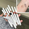 En samling dobbel-endede gel eyelinerblyanter og en highlighter-swatch på en hånd.