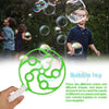 A child is blowing bubbles, with a green bubble wand toy visible in the foreground.
