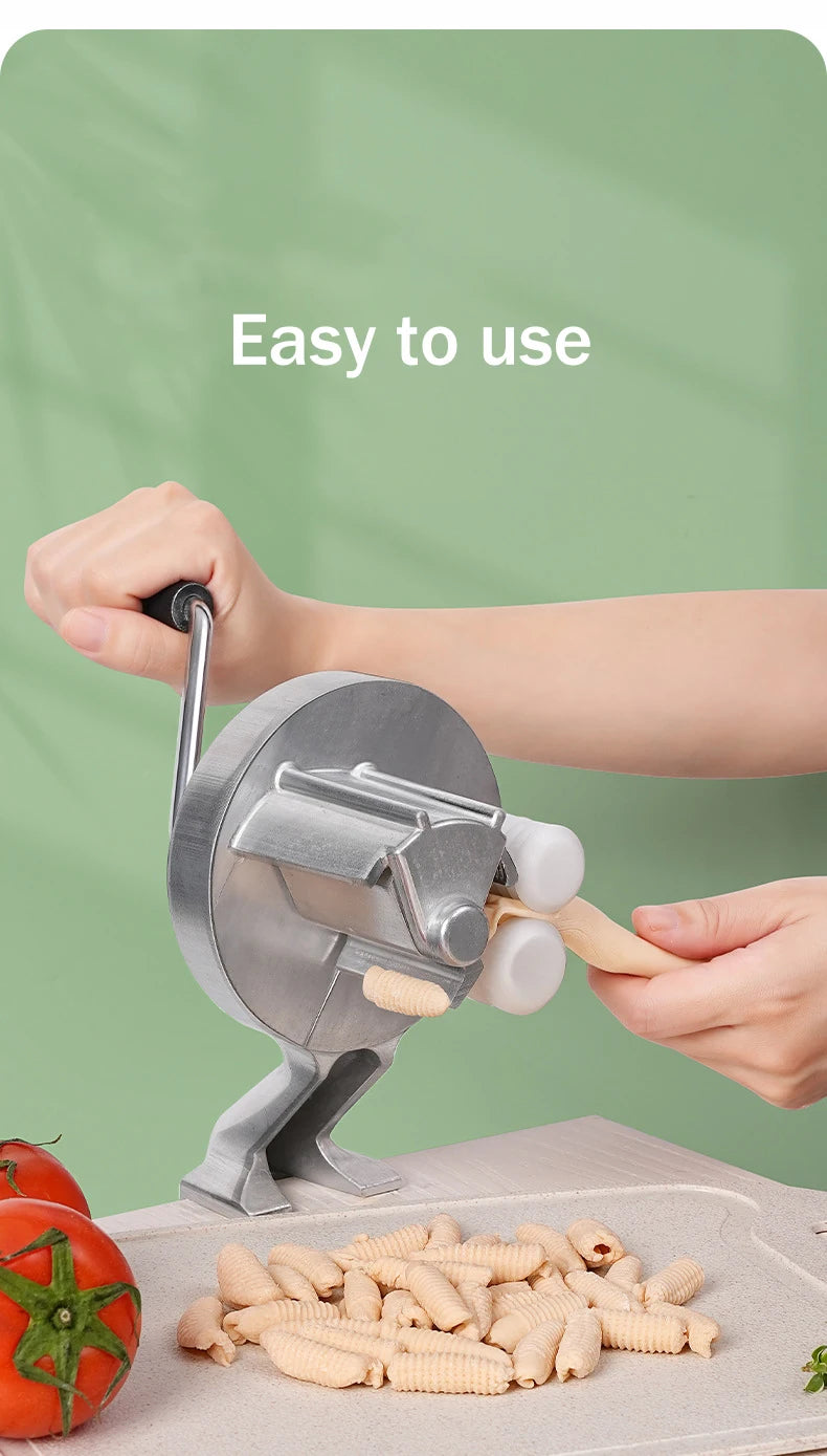 Hands are using a Cavatelli maker machine to roll out fresh pasta dough onto a cutting board.