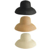 Three wide brim straw sun hats in black, beige, and cream.