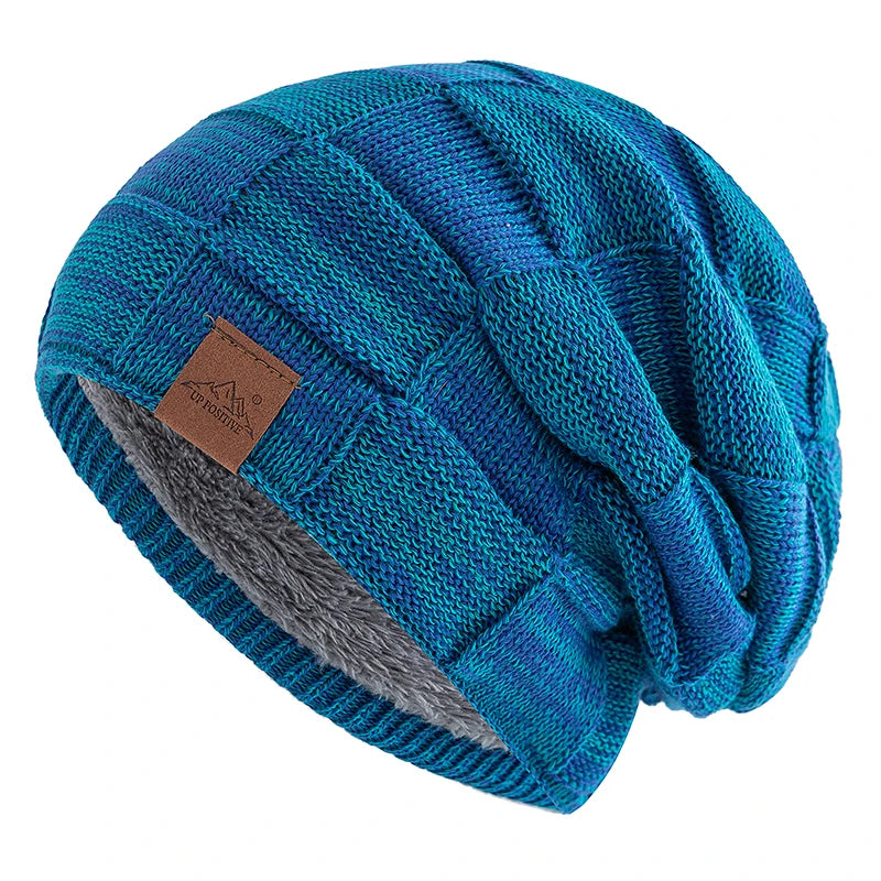 A teal and blue knit beanie with a slouchy fit and a gray accent stripe.