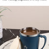 A dark blue stainless steel travel mug filled with coffee sits next to a white lid on a light surface.