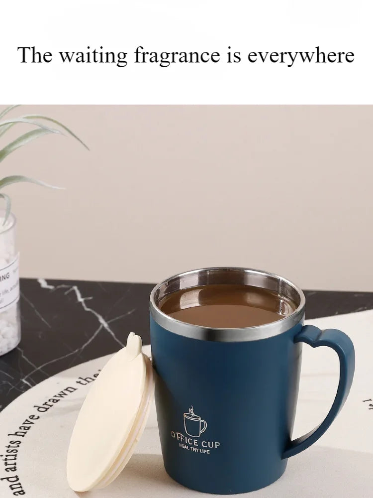 A dark blue stainless steel travel mug filled with coffee sits next to a white lid on a light surface.
