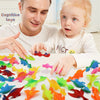 A man and a young girl are playing with a colorful dinosaur finger catapult toy set.