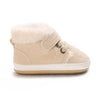 A pair of beige baby winter snow boots with a fluffy shearling lining and light-colored sole.