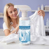 A woman is shown using a white bottle of clothing emulsifier spray to remove stains from a white cloth.