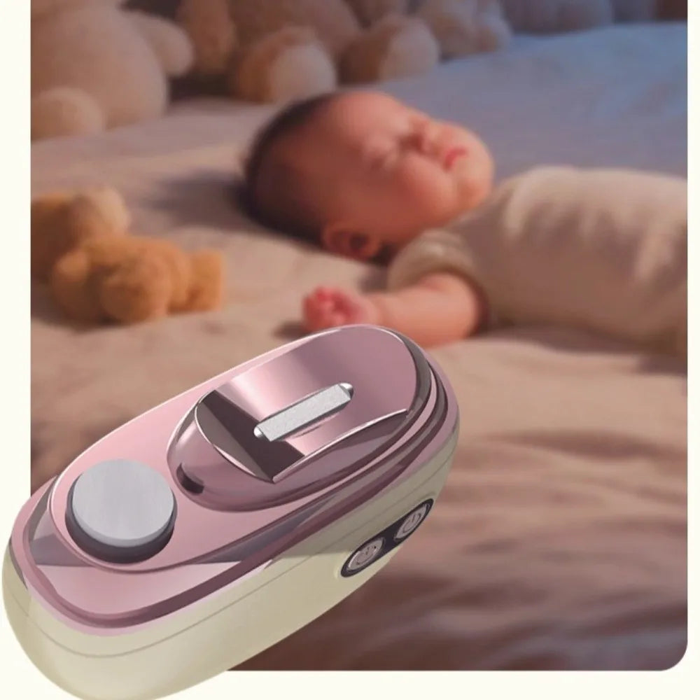 A pink and white rechargeable electric nail clipper and grinder resting on a soft blanket next to a sleeping baby.