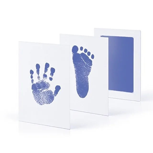 A set of three white framed prints showing blue handprints and footprints on a white background.