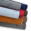 A stack of self-adhesive suede fabric rolls in various colors, including gray, blue, red, and brown.