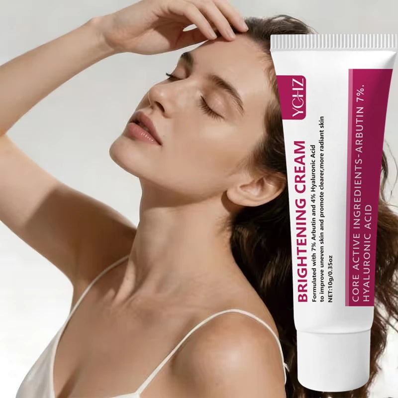 A tube of Brightening Cream with Arbutin, Hyaluronic Acid & Niacinamide is shown next to a woman applying the cream to her fa