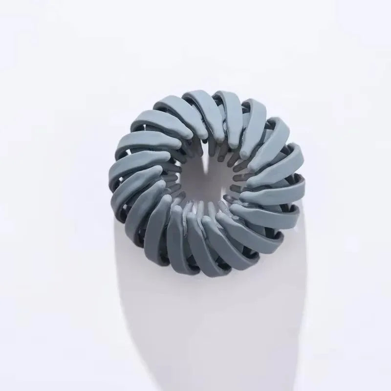 En sølvgrå fugleredehårklemme formet som en spiral til hestehaler.