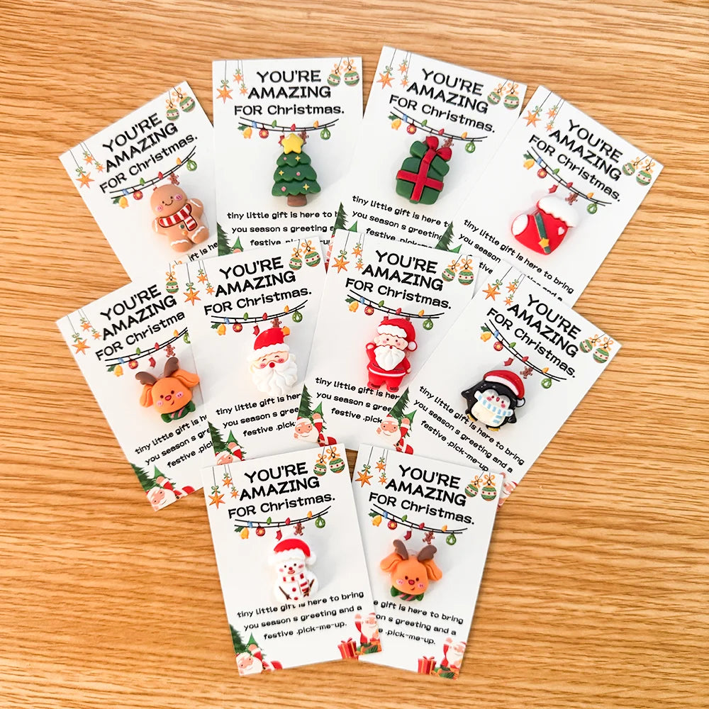 En samling av små juleklemkort med resin-charm og festlige julehilsener.