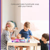 Two children are making handmade soap together at a table in a bright room.