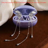 A pair of silver crystal butterfly earphone clips with tassels are displayed inside a purple case.
