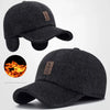 A black woolen knit baseball cap with earflaps shown from the front and side.