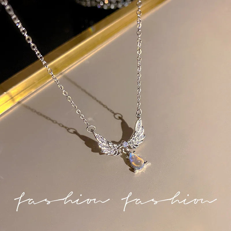 Silver crystal bow angel wings heart pendant necklace displayed on a light background.
