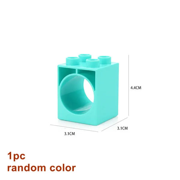 A teal plastic marble run building block piece with a circular track and funnels.