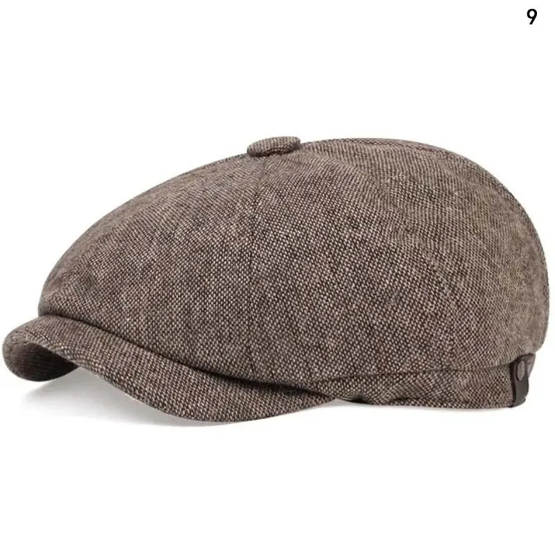 A close-up view of a brown tweed newsboy cap with a folded brim.