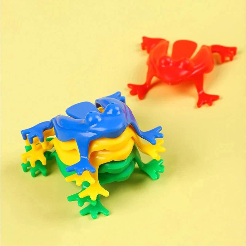 A set of colorful jumping frog toys in blue, yellow, and green are displayed on a light yellow background.