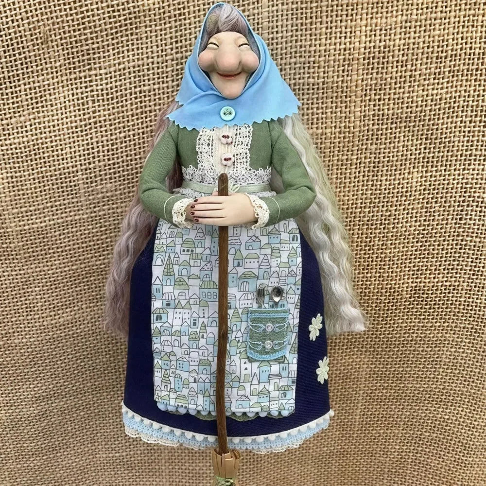 Handcrafted kitchen witch doll with antique charm wearing a green dress and blue hood
