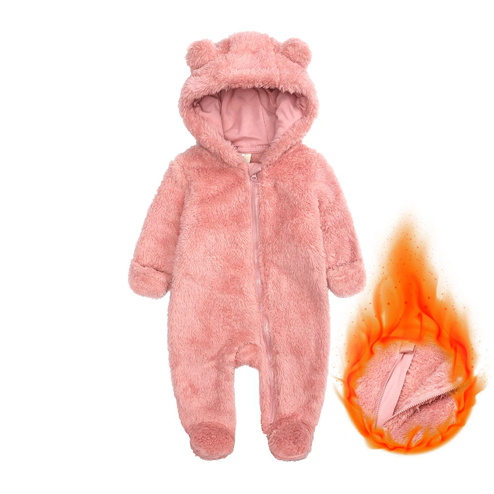 A pink fuzzy baby fleece hooded romper with a zipper, shown next to a flame.