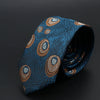 Corbata jacquard azul oscuro con diseños dorados y blancos, enrollada.