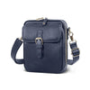 A dark navy vegan leather messenger bag with gold hardware and an adjustable strap.