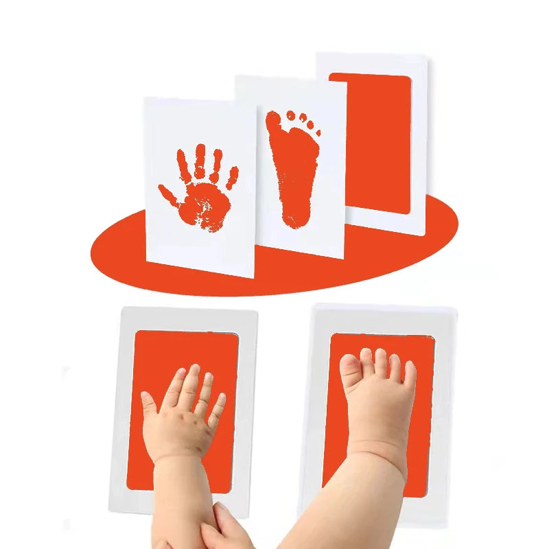 An inkless baby handprint and footprint keepsake kit showing various prints on white cards and an orange base.