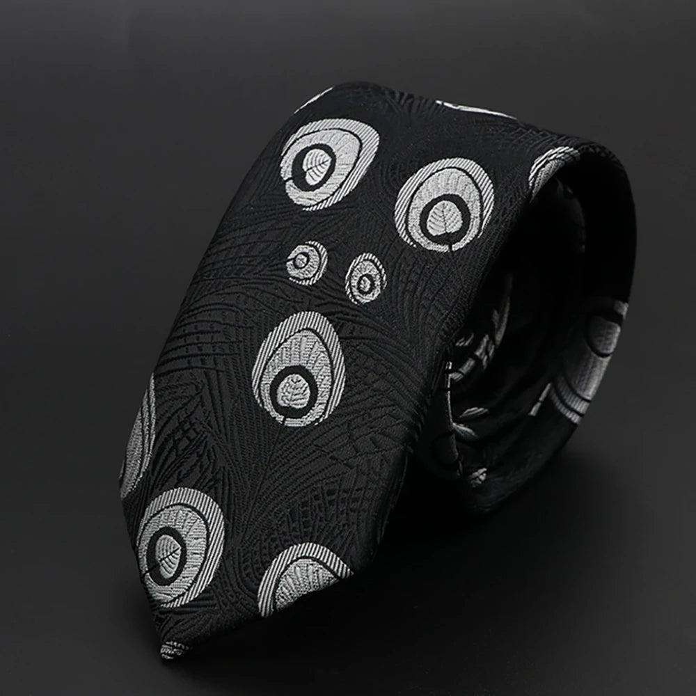 Corbata negra de jacquard con patrones circulares blancos, enrollada y drapeada.