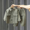 A boy's casual cotton shirt and cargo pants set in olive green fabric being displayed on a hanger.