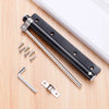 A black stainless steel automatic door closer with an invisible spring mechanism and mounting hardware on a wooden surface.