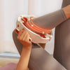 A person is using a full body massage roller with detachable handles on their leg, showing the massage points glowing.