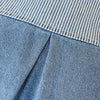 Close-up of blue denim fabric with a light vertical stripe detail.