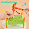 A set of orange and green Montessori hammer and nail toys for fine motor skill training, held by a hand.