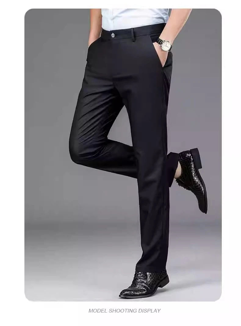 A man models black stretch straight-leg trousers with a white shirt and a wristwatch.