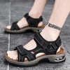A pair of black men's genuine leather air cushion sandals worn on a foot against a gray background.
