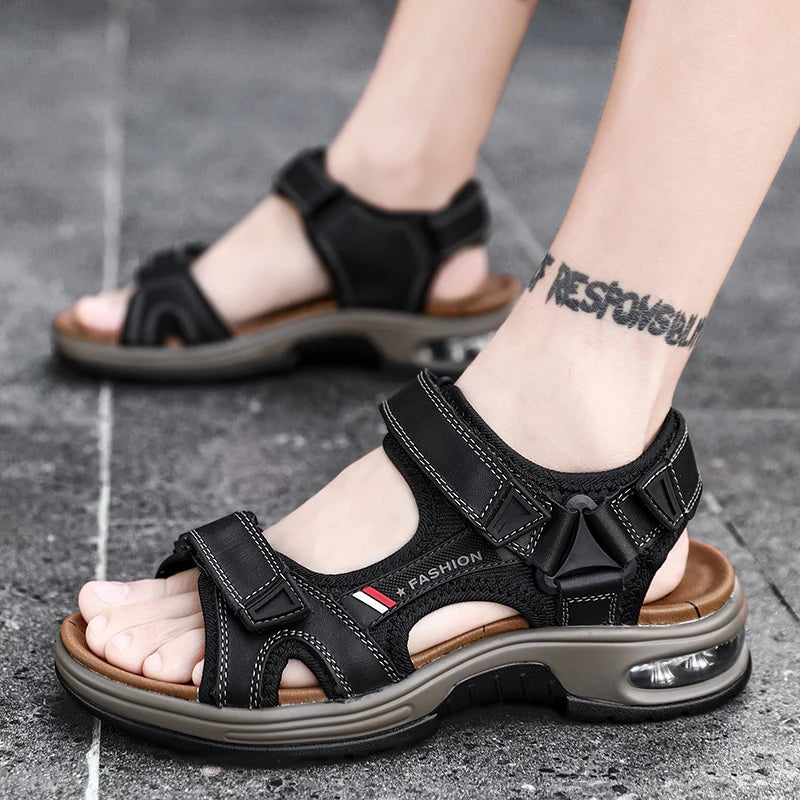 A pair of black men's genuine leather air cushion sandals worn on a foot against a gray background.