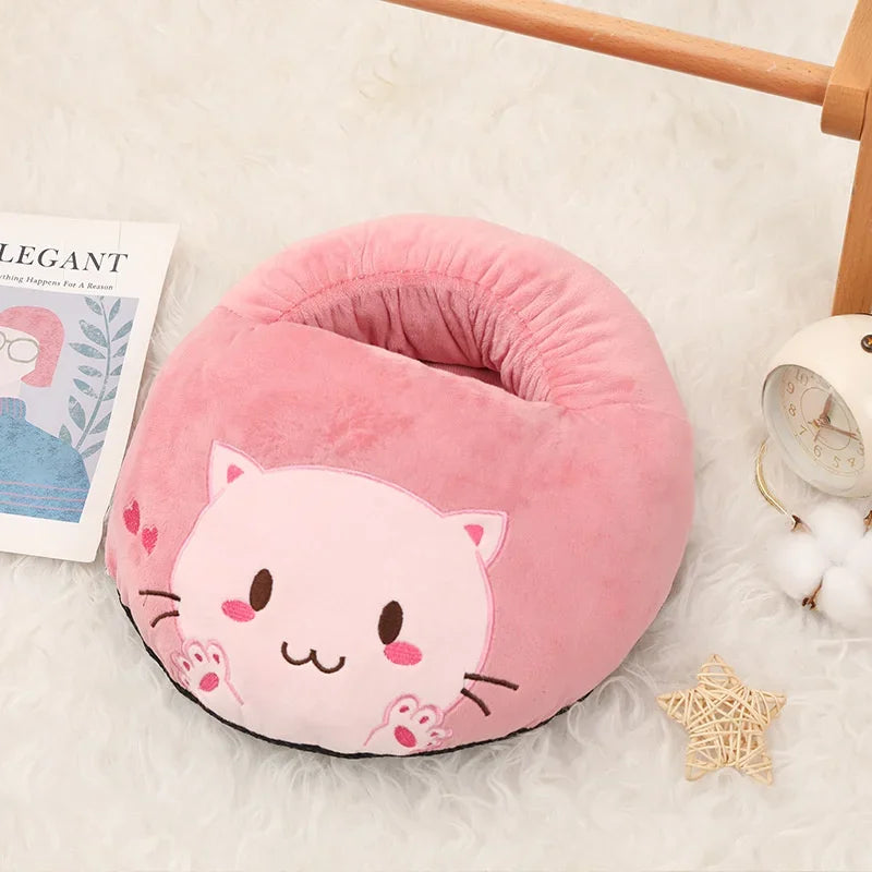 A pink cat-shaped cozy USB heated foot warmer with a soft fleece cover resting on a white surface.
