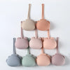 A collection of pink and beige silicone pacifier storage cases with lanyards arranged vertically.