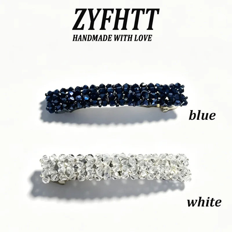 Dos hebras de cristales de strass hechos a mano, una azul y otra blanca, sobre fondo blanco.