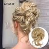 Mujer rubia con moño rizado despeinado y rizos sueltos.