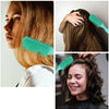 Mujer usa un peine desenredante verde azulado para masajear y desenredar su largo cabello castaño.